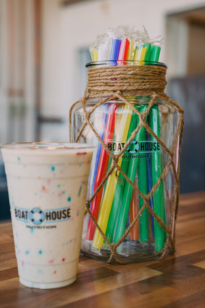 A cup of coffee and a jar with many colored straws.